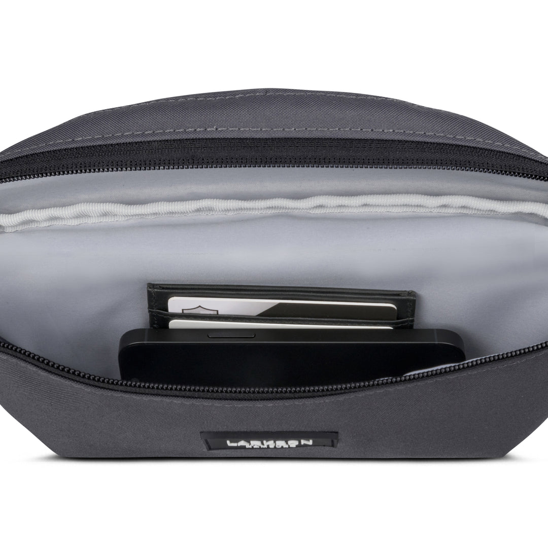 Graue LARKSON Bauchtasche Finn mit offener Tasche, sichtbar sind ein Smartphone und Karten