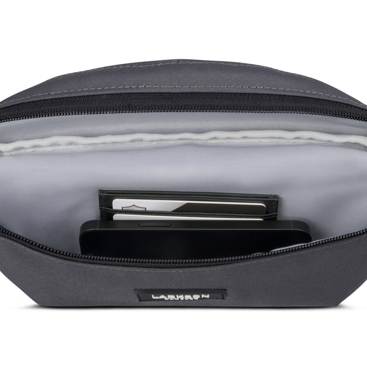 Graue LARKSON Bauchtasche Finn mit offener Tasche, sichtbar sind ein Smartphone und Karten