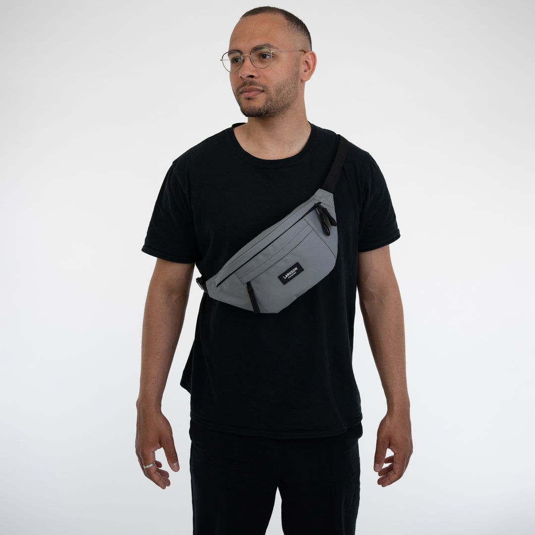 Mann trägt graue Bauchtasche Ole von Larkson über der Schulter zu schwarzem T-Shirt
