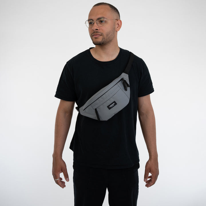 Mann trägt graue Bauchtasche Ole von Larkson über der Schulter zu schwarzem T-Shirt