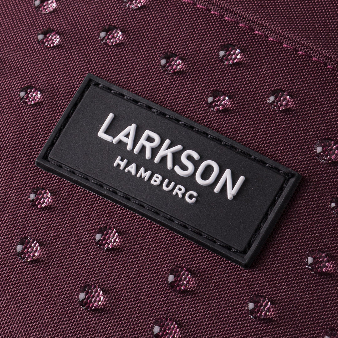 Nahaufnahme des wasserabweisenden Materials der Bauchtasche Ole in Beerenton mit LARKSON Hamburg Logo