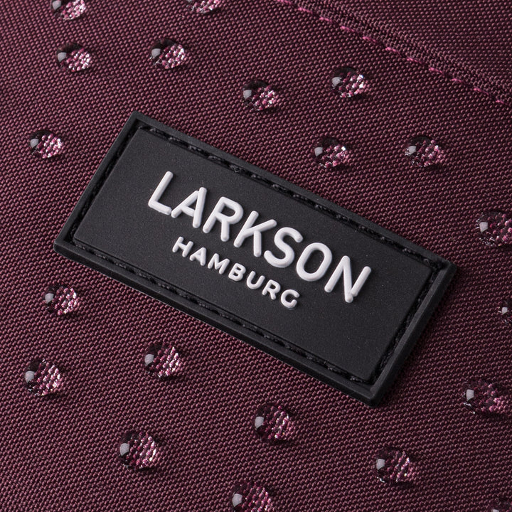 Nahaufnahme des wasserabweisenden Materials der Bauchtasche Ole in Beerenton mit LARKSON Hamburg Logo