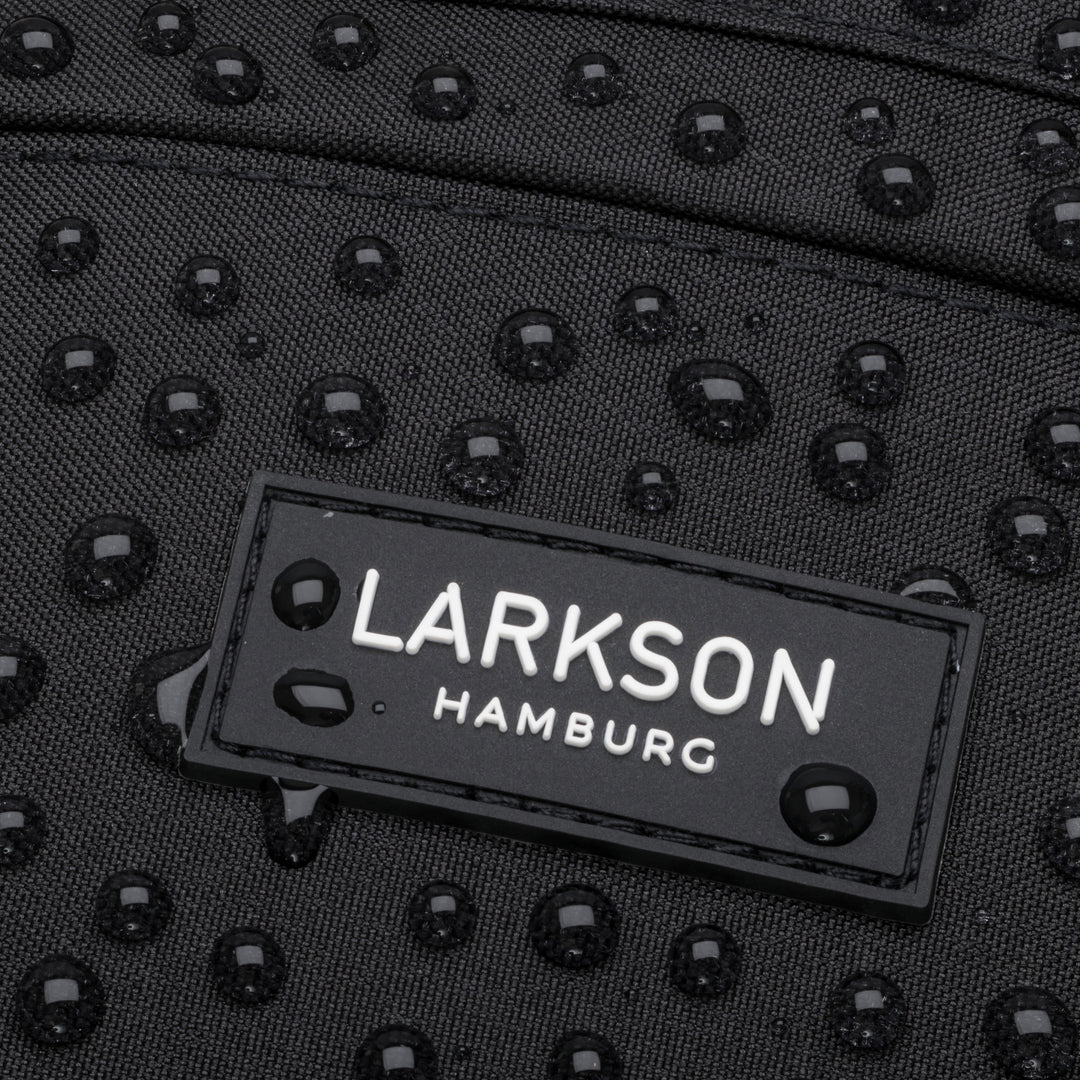 Wasserabweisendes schwarzes Material mit Larkson Hamburg Logo und Wassertropfen