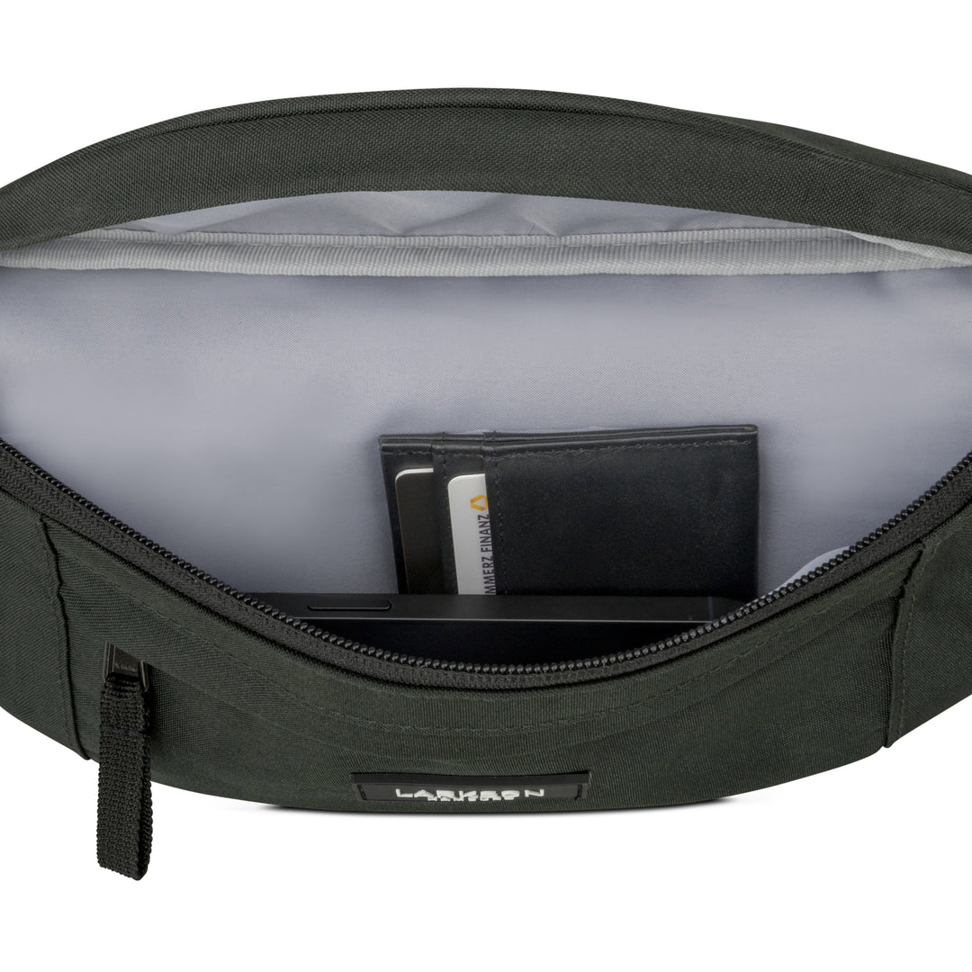 Grüne Bauchtasche Ole von Larkson mit geöffnetem Hauptfach, darin ein schwarzes Portemonnaie und Karten