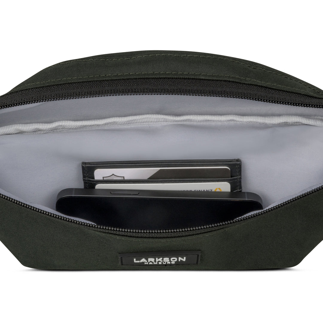 Offene grüne Bauchtasche Finn von Larkson mit Sicht auf Innenfächer, in denen Karten und ein Smartphone liegen