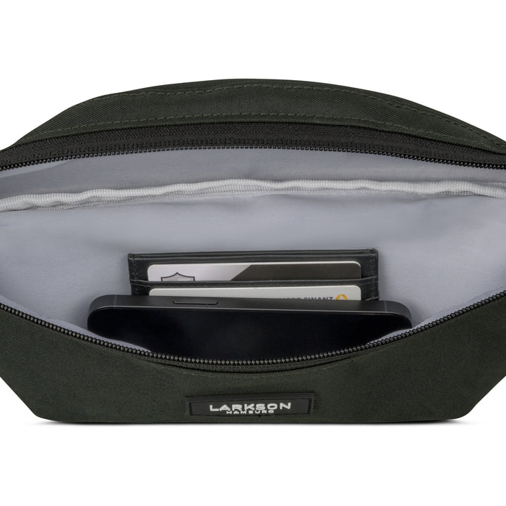 Offene grüne Bauchtasche Finn von Larkson mit Sicht auf Innenfächer, in denen Karten und ein Smartphone liegen