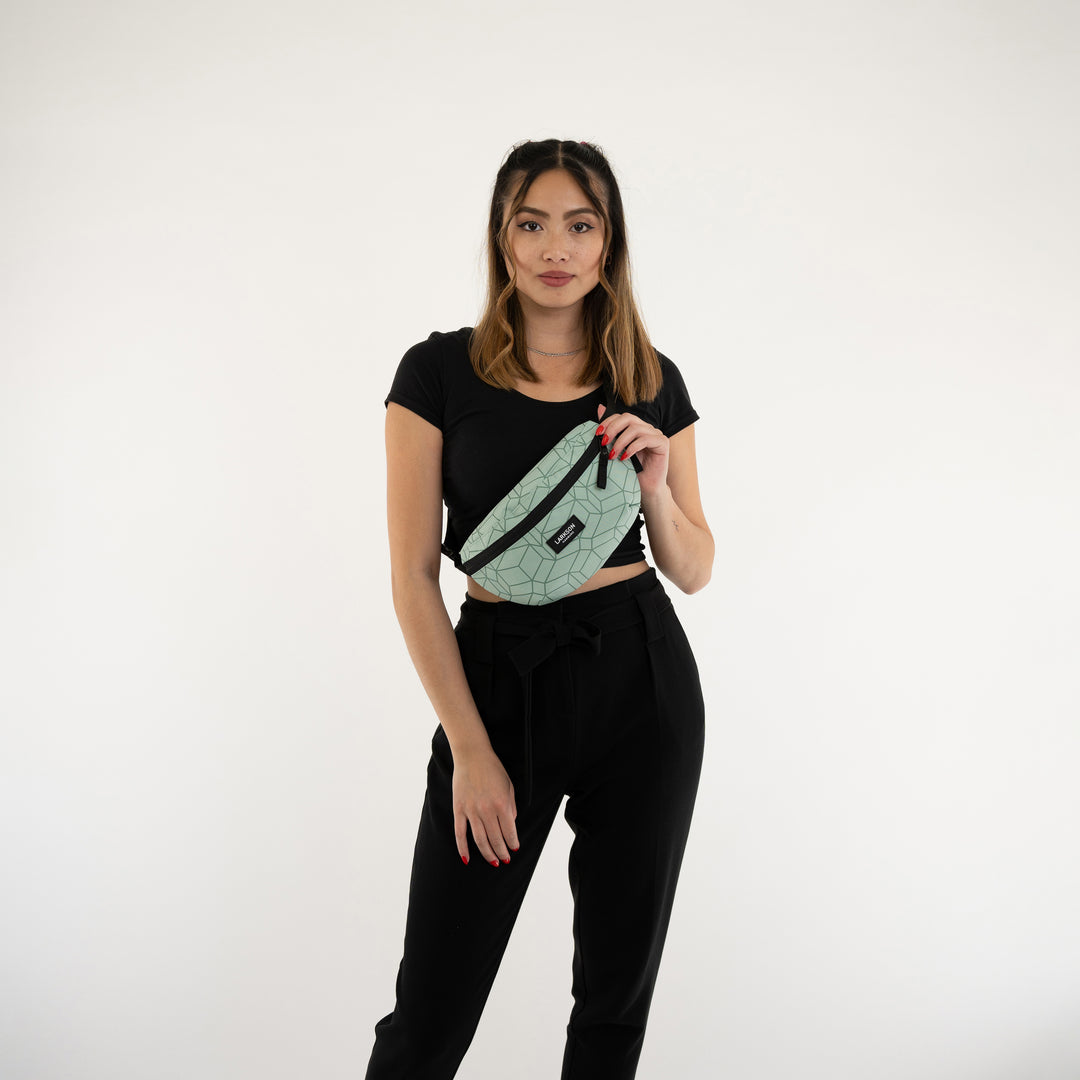Frau trägt mintfarbene LARKSON Bauchtasche Finn mit geometrischem Muster