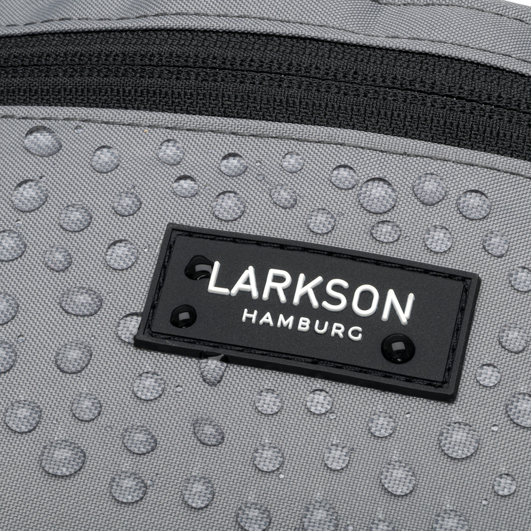 Nahaufnahme der grauen, regenfesten Bauchtasche Finn von Larkson mit Wassertropfen und schwarzem Reißverschluss