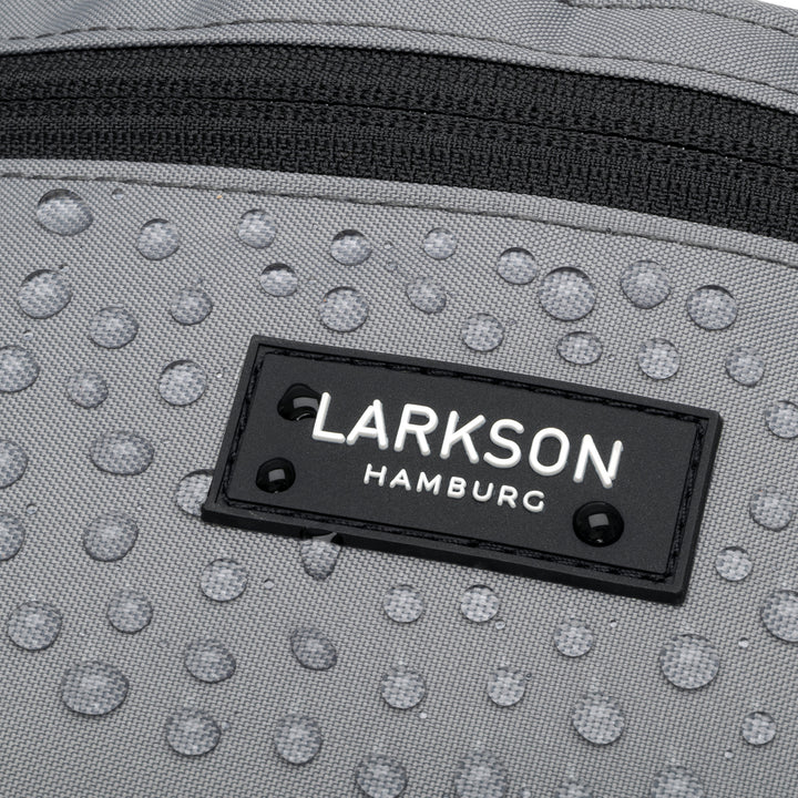 Nahaufnahme der grauen, regenfesten Bauchtasche Finn von Larkson mit Wassertropfen und schwarzem Reißverschluss