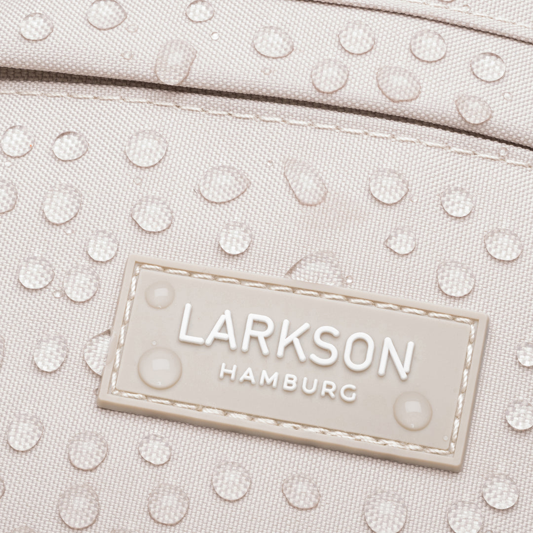 Nahaufnahme der wasserabweisenden beige Bauchtasche 'Ole' von Larkson mit sichtbaren Wassertropfen auf dem Material