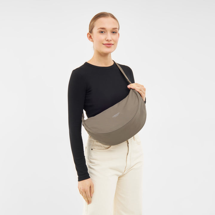 Frau trägt mittlere Half Moon Bag Solveig von LARKSON in graubraun über der Schulter