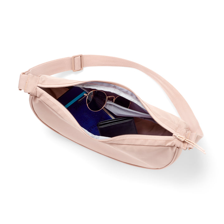 Halbmondtasche Solveig Medium in Rosé geöffnet mit Brille, Buch und Geldbörse innen