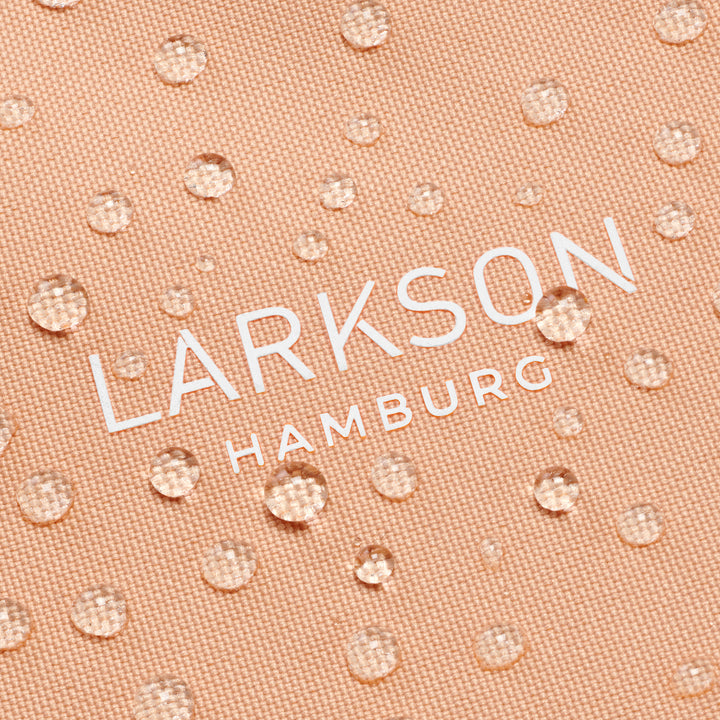 Detail der wasserabweisenden Oberfläche der peachfarbenen Half Moon Bag Solveig Medium mit weißem LARKSON Hamburg Schriftzug