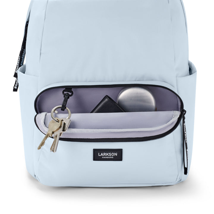 Hellblauer LARKSON Rucksack No 3 mit geöffnetem Frontfach, Schlüsselanhänger, schwarzem Portemonnaie und silberner Dose