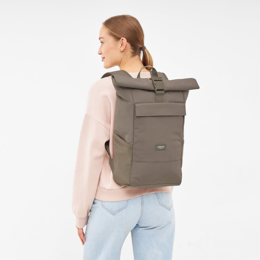 Rolltop Rucksack No 4 von LARKSON in Gravel an Frau mit hellrosa Pullover und blauer Jeans