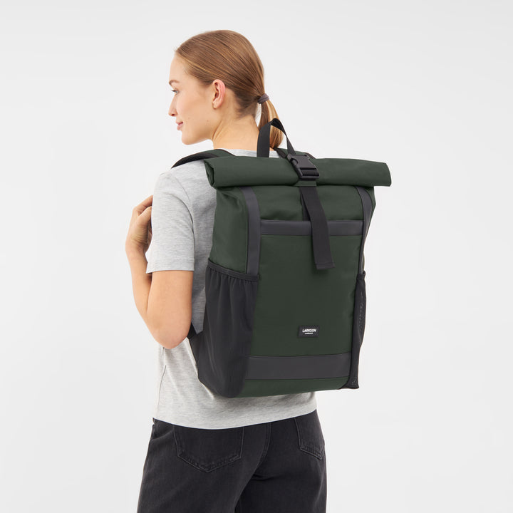 Frau trägt olivgrünen Rolltop-Rucksack No 2 von Larkson mit schwarzen Details