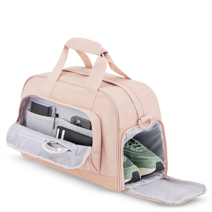 Rosa Reisetasche Finja mit Schuhfach, geöffnet, zeigt grüne Schuhe und Fronttasche mit Smartphone, Portemonnaie und Kabel