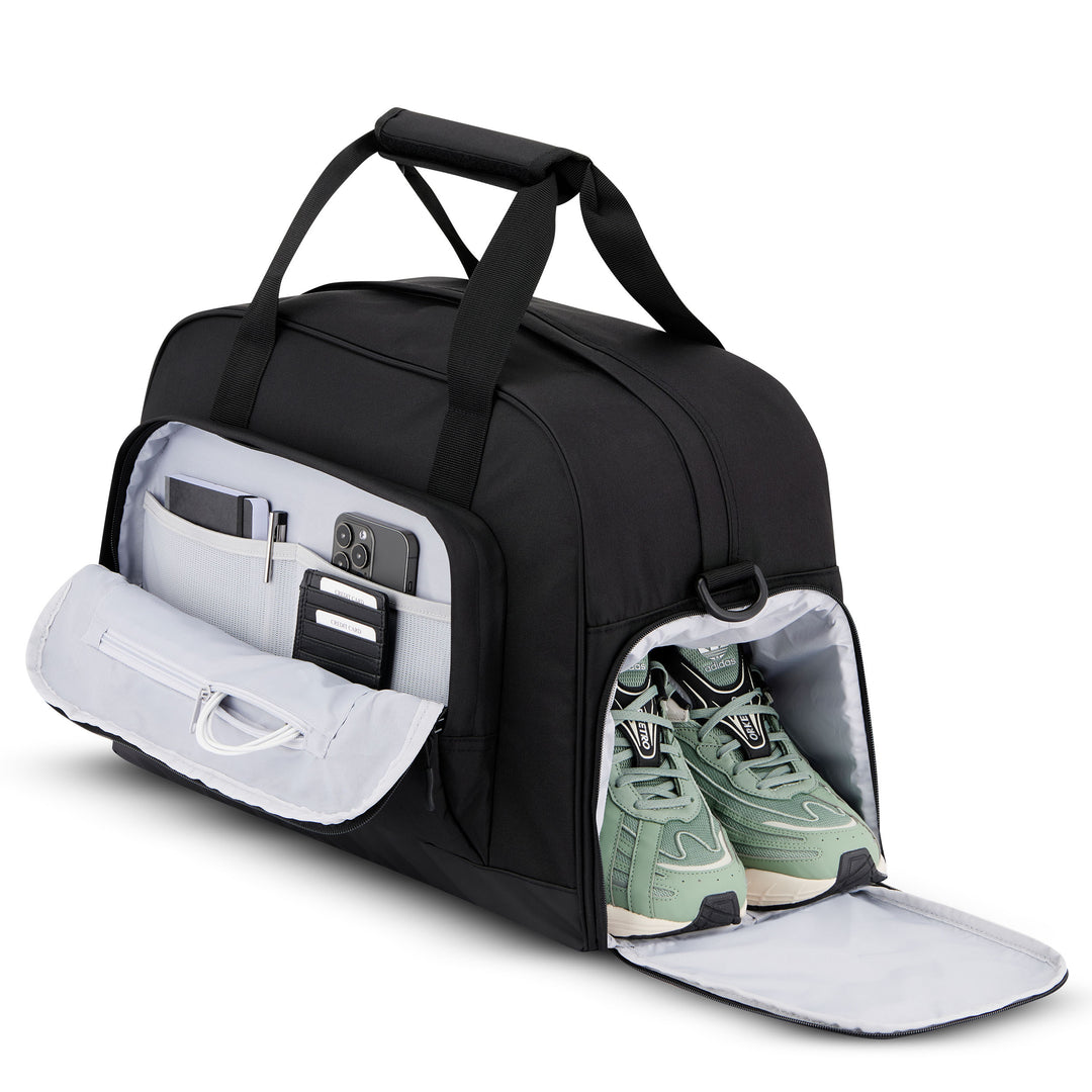 Schwarze Reisetasche Finja von LARKSON mit Schuhfach und mehreren Fächern, geöffnet mit sichtbaren grünen Sportschuhen