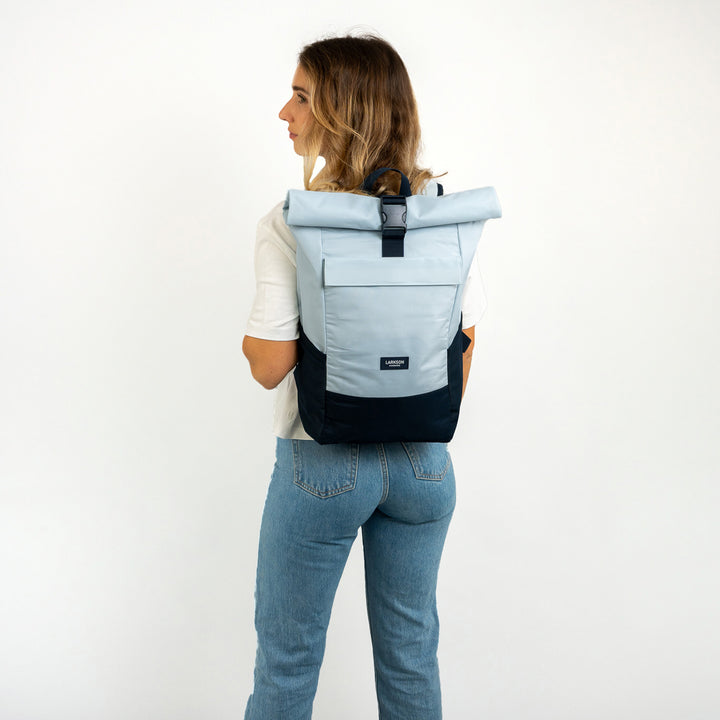 Dame trägt blauen Rolltop Rucksack No 4 von Larkson mit schwarzem Boden