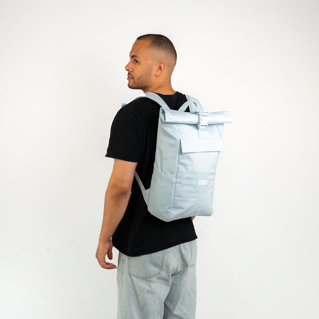 Mann trägt hellblauen Rolltop Rucksack No 4 von Larkson mit robustem, rechteckigem Design