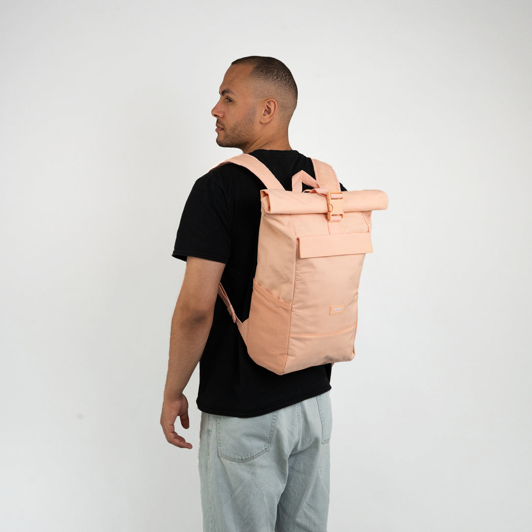 Mann trägt peachfarbenen Rolltop Rucksack No 4 von Larkson aus Textil mit Schnalle