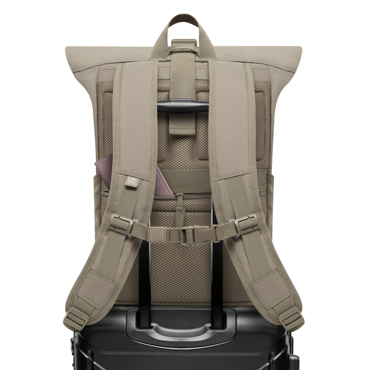 Beiger Rolltop Rucksack No 4 von LARKSON mit gepolsterten Schultergurten, Brustgurt und Befestigung an einem schwarzen Koffertrolley
