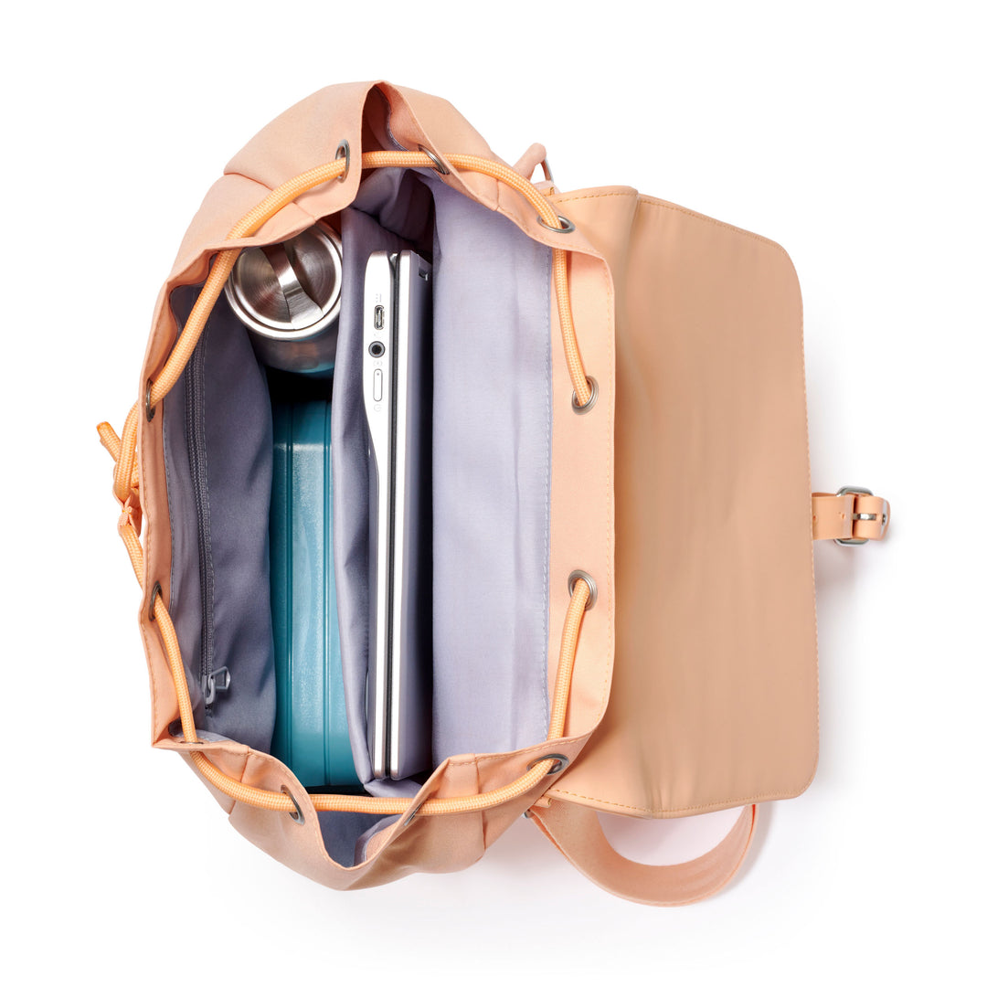 Offener pfirsichfarbener Rucksack Ida mit Laptopfach, Trinkflasche und Box im Innenraum