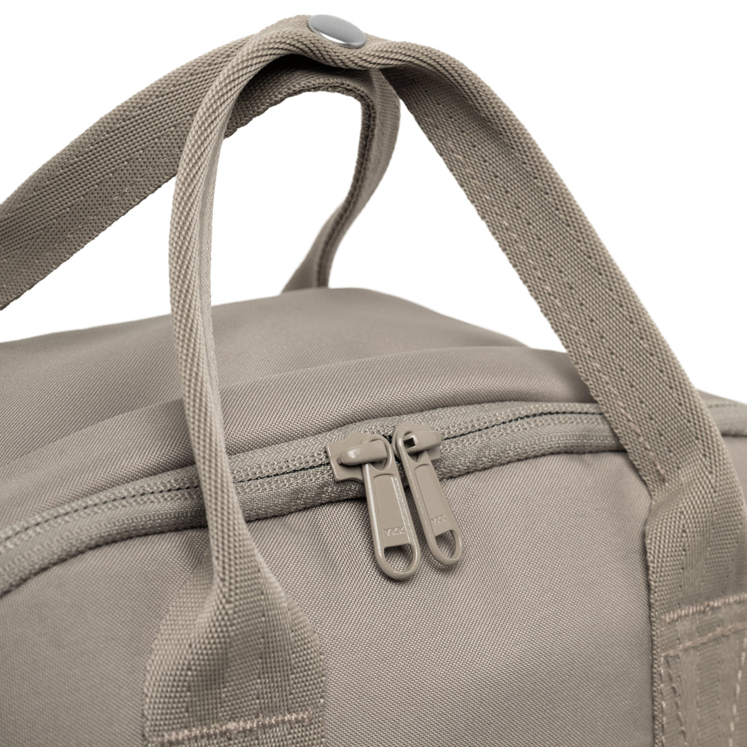 Nahaufnahme des hellgrauen Rucksack No 6 von LARKSON mit zwei Reißverschlüssen und stabilen Tragegriffen