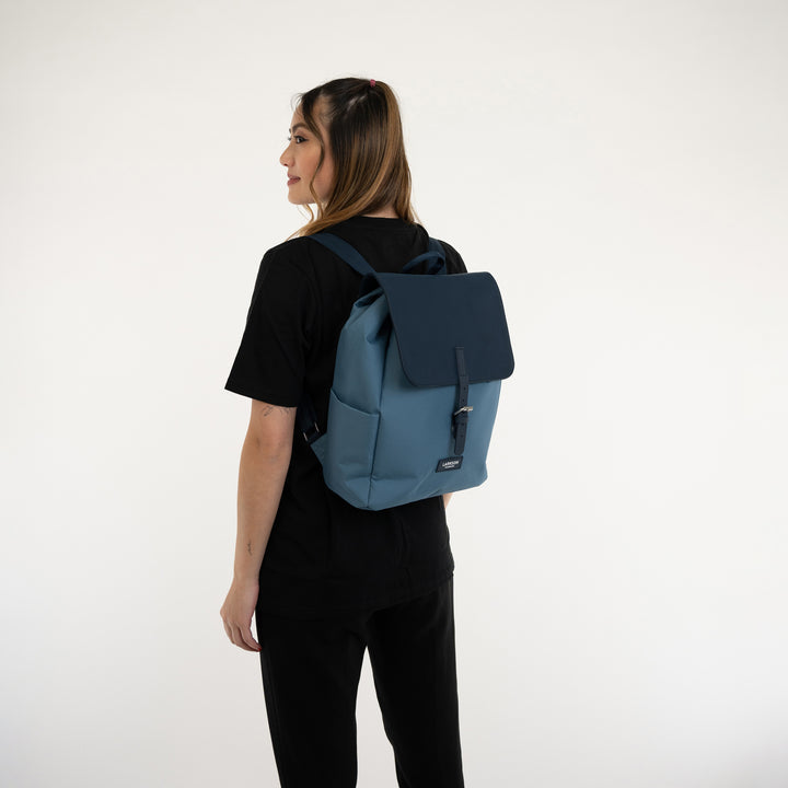 Damen trägt blauen LARKSON Rucksack Ida mit schwarzem Deckel und verstellbaren Schultergurten