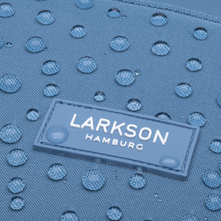 Wasserabweisendes blaues Material mit weißen LARKSON HAMBURG Logo und Wassertropfen