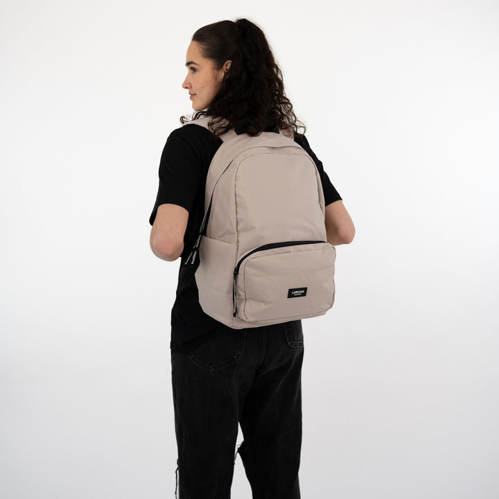 Beige LARKSON Rucksack No 3 getragen von jungen Frau in schwarzem T-Shirt und Hose