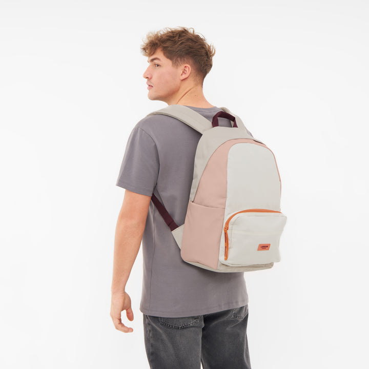 Junger Mann trägt beigen und rosafarbenen Rucksack No 3 von LARKSON mit Fronttasche