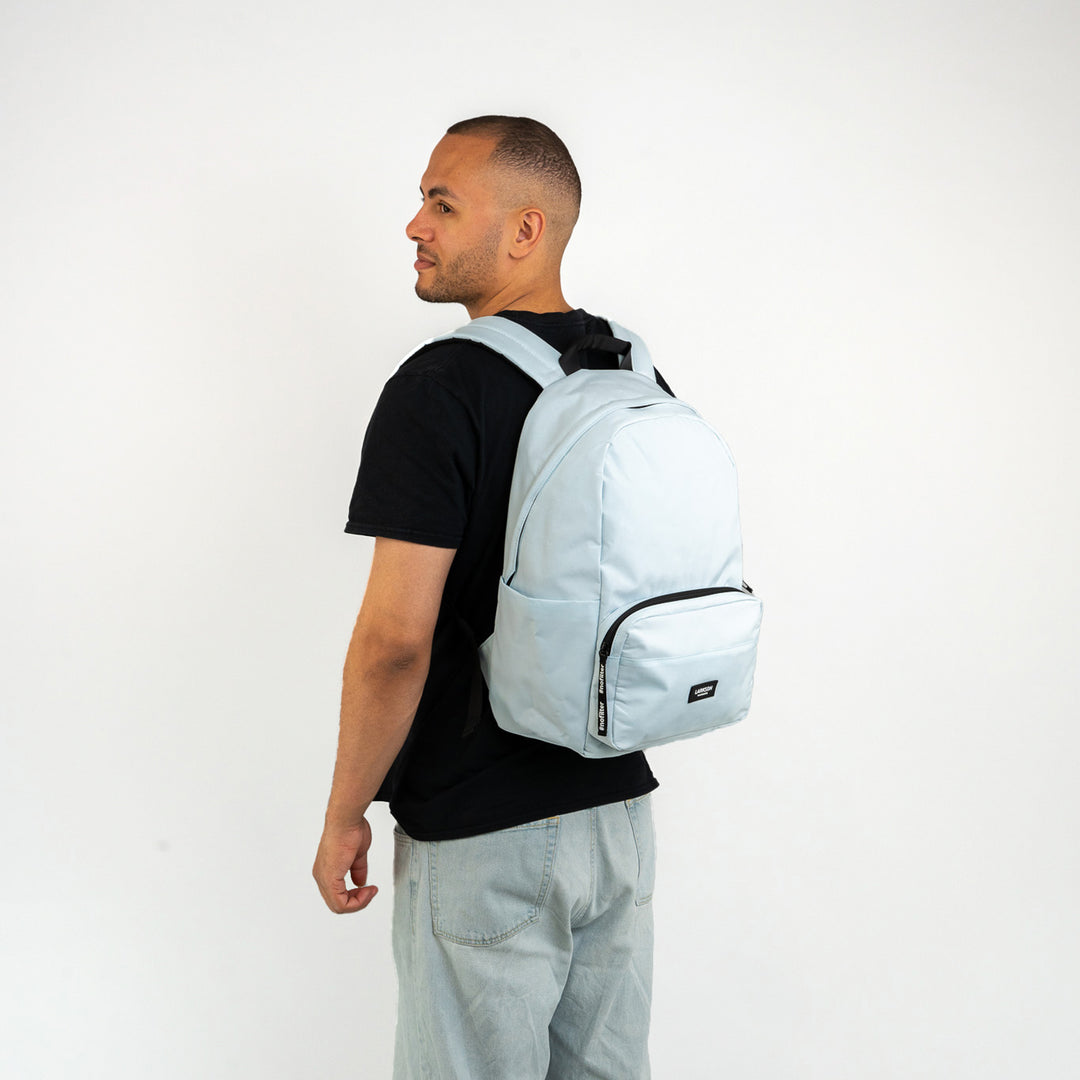Mann trägt hellblauen LARKSON Rucksack No 3 mit Reißverschlusstasche und seitlichen Fächern
