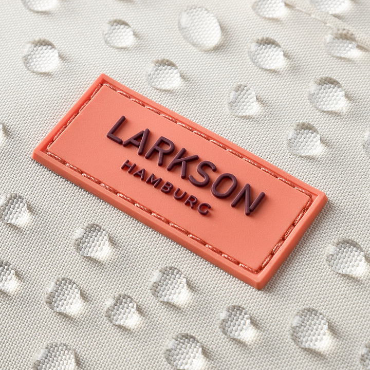 LARKSON Markenlogo auf beigem wasserdichtem Rucksackmaterial mit Wasserperlen