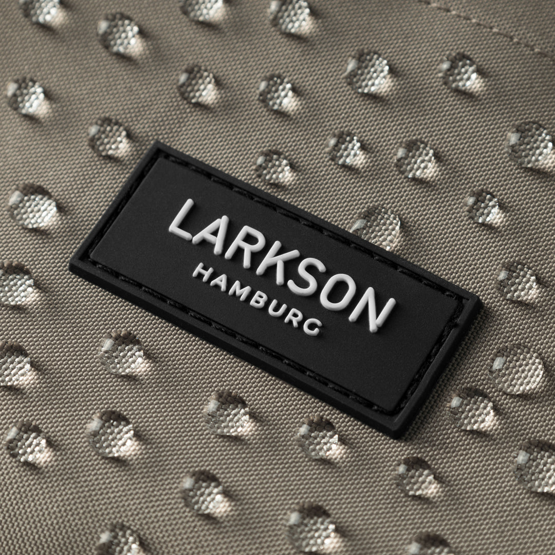 Wasserdichte graue Stoffoberfläche mit Wassertropfen und schwarzem LARKSON Hamburg Logoetikett