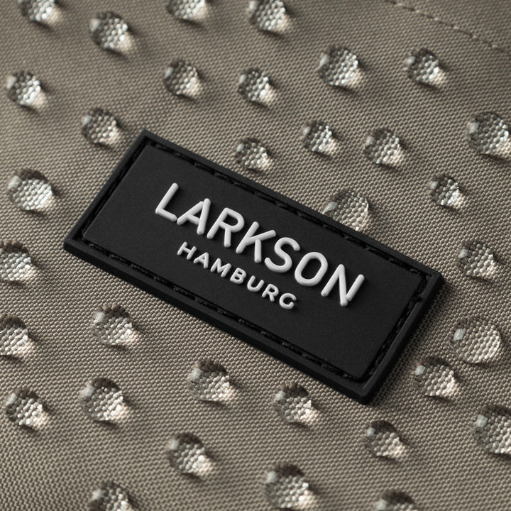 Wasserdichte graue Stoffoberfläche mit Wassertropfen und schwarzem LARKSON Hamburg Logoetikett