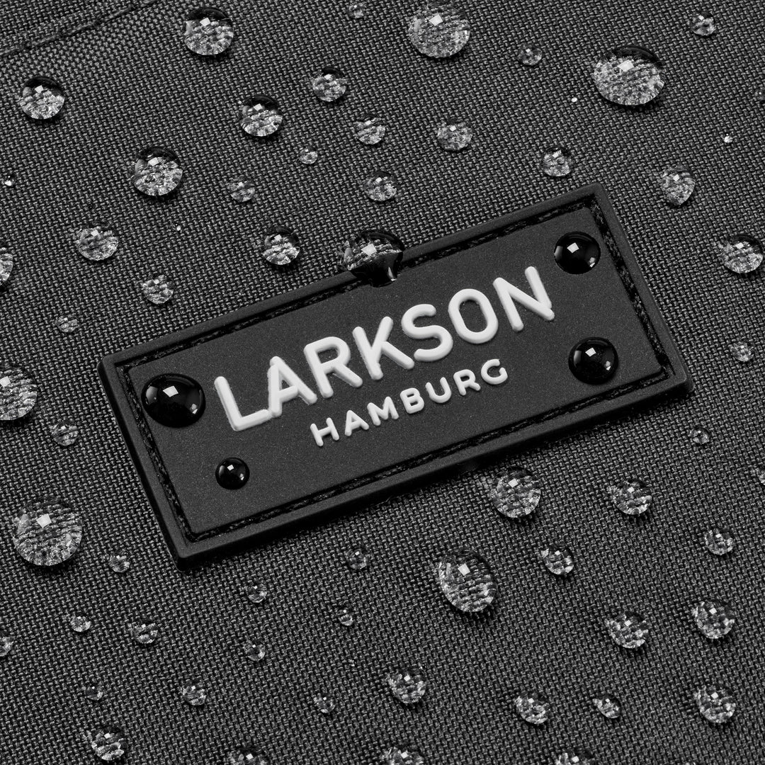 Nahaufnahme des LARKSON Hamburg Logos auf wasserabweisendem Stoff mit Wassertropfen