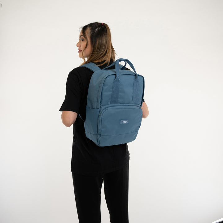 Frau mit blauem Rucksack No 6 der Marke Larkson, modernes Design, von hinten
