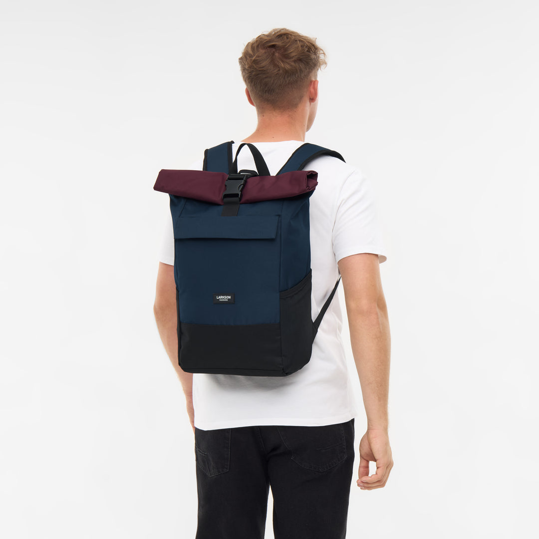 Rolltop Rucksack No 4 von LARKSON in Blau, Berry und Schwarz, getragen von einem Mann von hinten