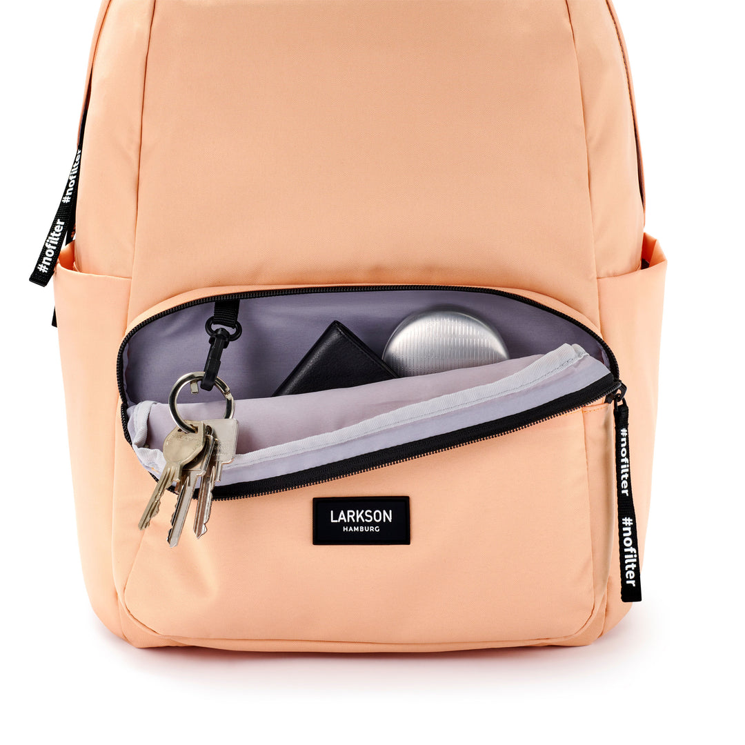 Pfirsichfarbener LARKSON Schulrucksack No 3 mit geöffnetem vorderem Reißverschlussfach, Schlüsselanhänger mit Schlüsseln, schwarzer Geldbörse und silberner Etui innen