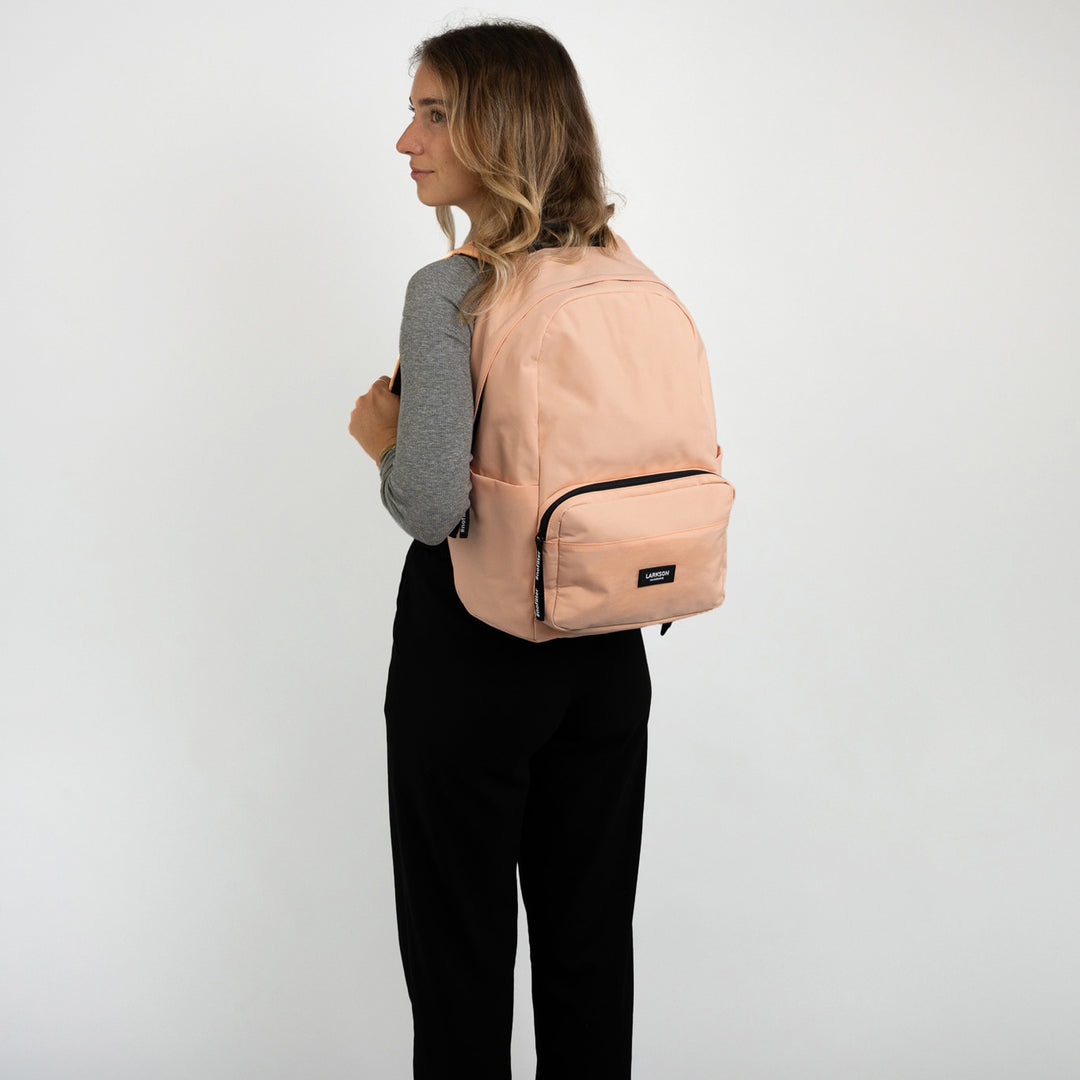 Rucksack No 3 in Pfirsichfarbe von Larkson getragen von Mädchen mit grauem Oberteil und schwarzer Hose