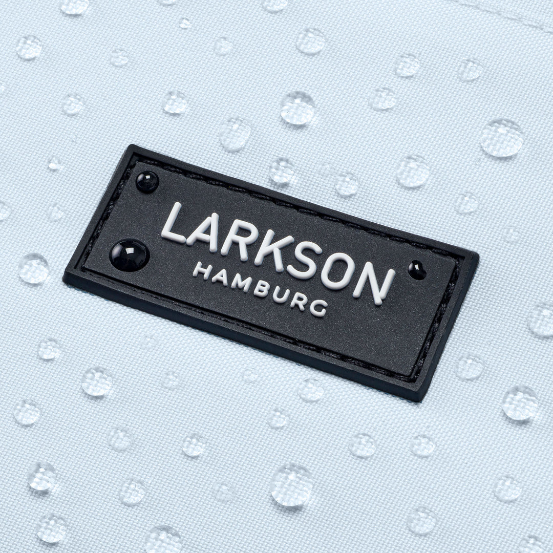 Schwarzes LARKSON Hamburg Logo auf wasserabweisendem hellblauem Schulrucksack mit sichtbaren Wassertropfen