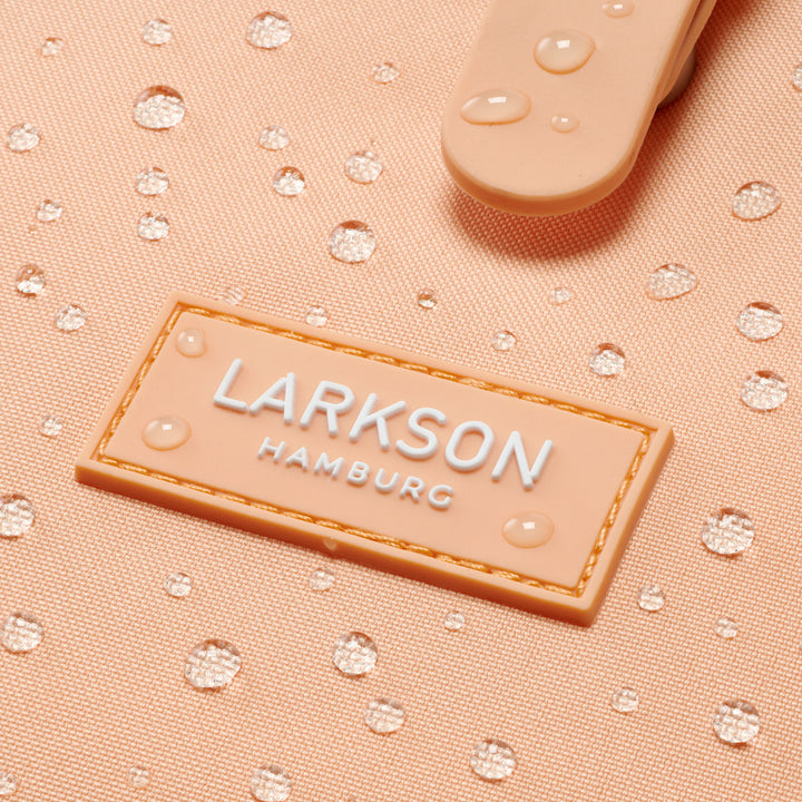 Nahaufnahme vom wasserabweisenden Material und Logo des rosa LARKSON Rucksack Ida