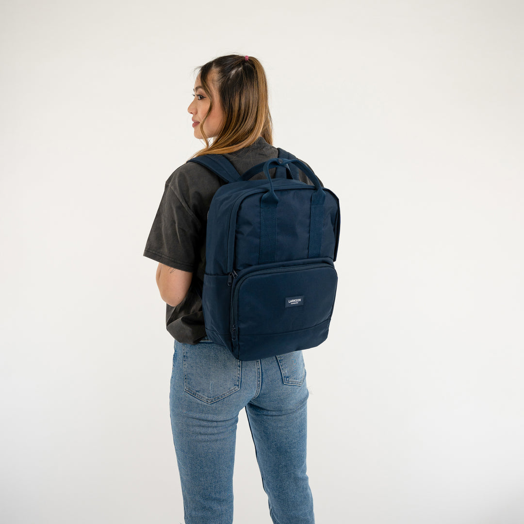 Dunkelblauer LARKSON Rucksack No 6 getragen von Frau mit schwarzem T-Shirt und Jeans