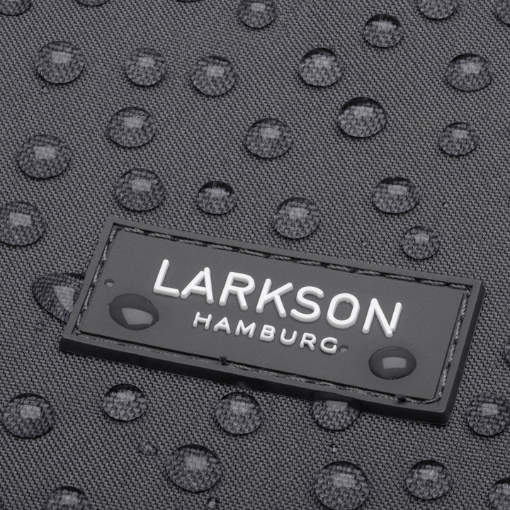 LARKSON Hamburg Markenlabel auf dunkelgrauem, wasserabweisendem Rucksackmaterial mit Wassertropfen