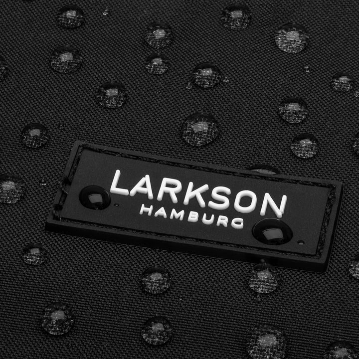 Detailaufnahme des schwarzen wasserabweisenden Damenrucksacks Ida mit LARKSON Hamburg Logo und Wassertropfen