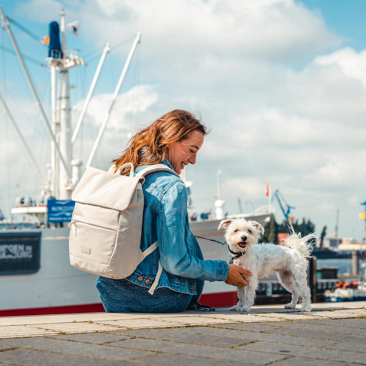 Frau am Hafen mit beigem Damenrucksack 'Rucksack Ronja' und kleinem weißen Hund