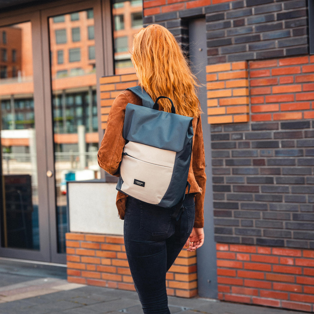 Frau mit rotem Haar trägt graubeigen Damenrucksack 'Rucksack Ronja' von LARKSON auf dem Rücken
