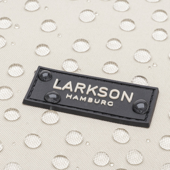 Wasserdichte graubeige Rucksackoberfläche mit schwarzem LARKSON Hamburg Label und Wasserperleneffekt