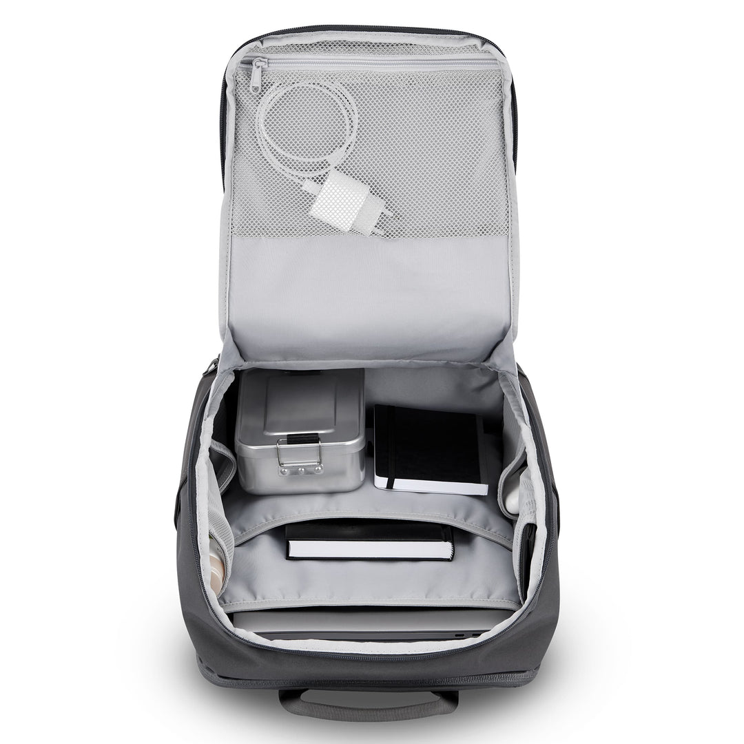 Geöffneter grauer Rucksack Niklas mit Innenfächern, Ladekabel, Metallbox und Notizbüchern
